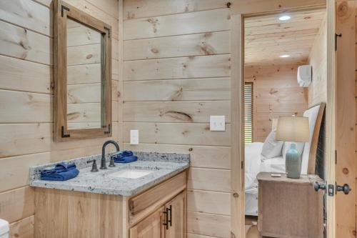 een badkamer met een wastafel en een spiegel bij Getaway Cottage - Creek Front, WIFI, Free Attraction Tickets in Cosby