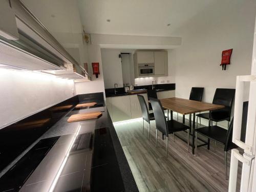 cocina y comedor con mesa y sillas en Luxury 6 Bedroom House, all with En-suite bathroom - West London - Wembley Stadium, OVO Arena 5 km, en Greenford