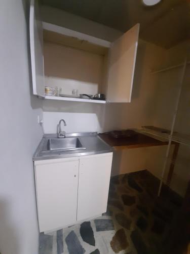 uma pequena cozinha com um lavatório num quarto em CERCA AL AEROPUERTO CONTRALORIA AL LADO HOTEL TORREON No ES DOS QUEBRADAS MEDIA CUADRA ESTACION UCUMARI 30 AGOSTO em Pereira