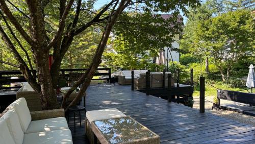 a wooden deck with couches and a tree at ユニテ蔵王ジョーニダ リゾート in Yamagata
