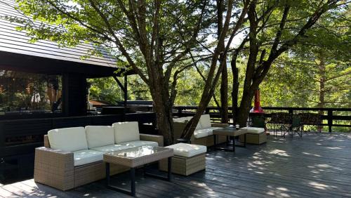 a group of white couches and tables on a patio at ユニテ蔵王ジョーニダ リゾート in Yamagata
