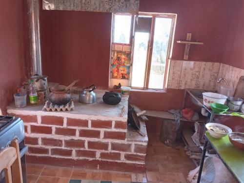 OcosuyoにあるHospedaje jatariのキッチン(レンガ造りの暖炉、窓付)