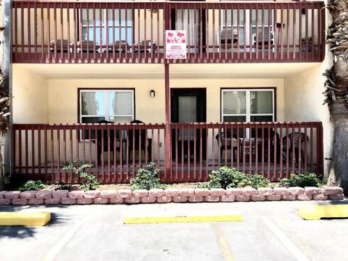 a building with a red fence and tables and chairs at 1st Floor 2 Bd 2 Ba Condo w Beach View& Pool in South Padre Island