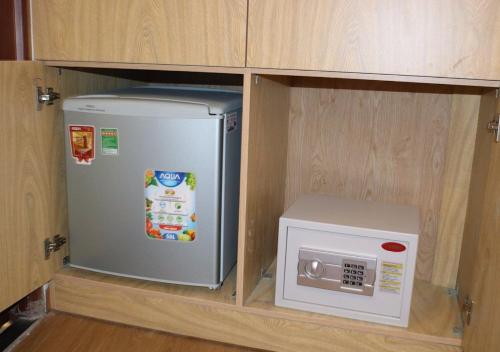 a refrigerator and a microwave in a cabinet at Saigoneer Hotel in Ho Chi Minh City