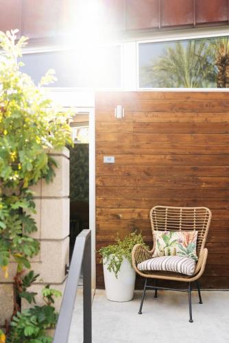 a rattan chair with a pillow on a patio at ARRIVE Palm Springs - Adults Only in Palm Springs