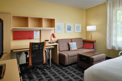 Habitación de hotel con cama, escritorio y sofá en TownePlace Suites Ann Arbor en Ann Arbor