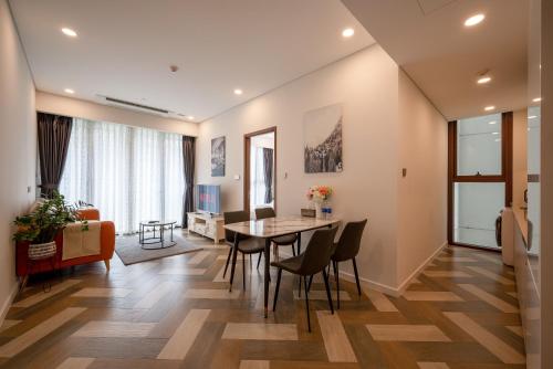 a dining room and living room with a table and chairs at Metropole Thu Thiem Condo Apartment in Ho Chi Minh City