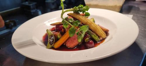 a plate of food with vegetables on a table at Australian Homestead Motor Lodge in Wagga Wagga