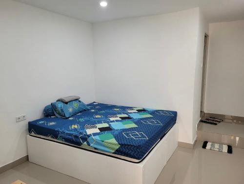 a bed with a blue comforter in a room at Beverly Residence in Praya