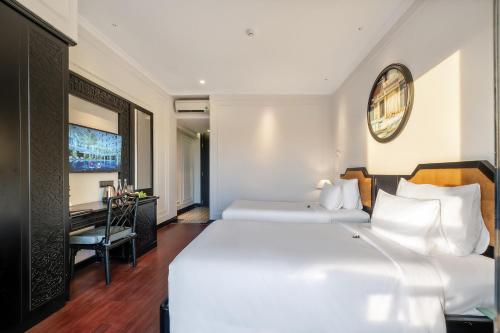 um quarto com uma grande cama branca e uma secretária em Hadana Boutique Resort HoiAn - former Belle Maison Hadana HoiAn em Hoi An
