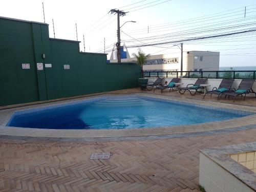 a large swimming pool with chairs around it at Natal Plaza Suítes- Ponta Negra in Natal