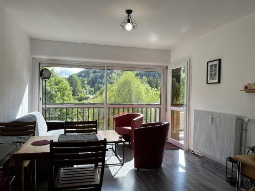 - un salon avec une table, des chaises et une grande fenêtre dans l'établissement Appartement fonctionnel à Villard-de-Lans, balcon, parking gratuit - FR-1-548-40, à Villard-de-Lans