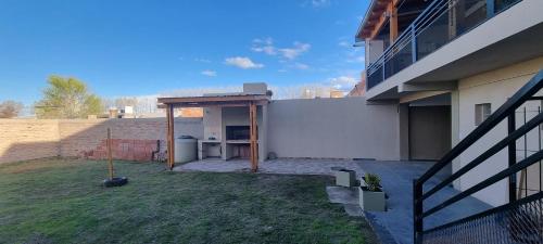 a backyard with a patio with a table and a building at Complejo Boulevard Plottier in Plottier
