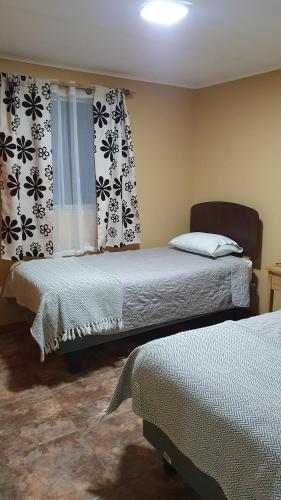 a bedroom with two beds and a window at Rincon del Inca in San Pedro de Atacama