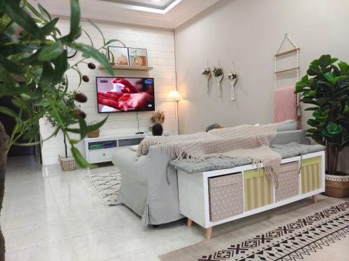 a living room with a couch and a tv on a wall at Glamstay BatuRakit by Beach (Netflix,Umt,Unisza,Ipg) in Kuala Terengganu