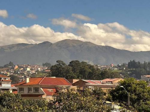a view of a city with mountains in the background at Sucre Suites Cuenca in Cuenca
