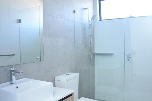 a bathroom with a shower and a toilet and a sink at New 2-story house with 4 bedrooms and 3 shower rooms in Burwood