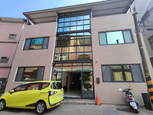 a small yellow car parked in front of a building at Jing Cheng Homestay in Jincheng
