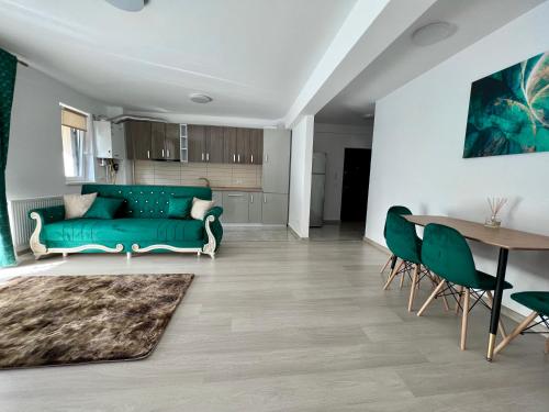 a living room with a green couch and a table at Trippin Iasi Apartament in Iaşi