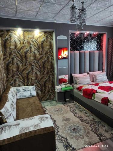 a bedroom with two beds and a wall with a mural at Komfort Lux Centre Karakol in Karakol