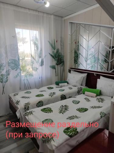 a bedroom with two beds and a window at Komfort Lux Centre Karakol in Karakol