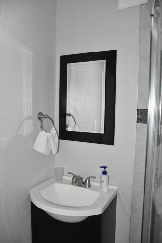 Un baño blanco con lavabo y espejo. en Departamento María. La Crucecita Huatulco., en Santa Cruz Huatulco