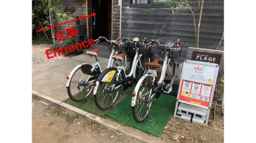 - deux vélos garés à côté d'un panneau dans l'établissement Plage Yuigahama, à Kamakura