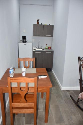 cocina con mesa de madera, sillas y fregadero en Departamento María. La Crucecita Huatulco., en Santa Cruz Huatulco