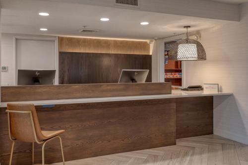 a lobby with a wooden counter with a chair at Staybridge Suites Allentown Airport Lehigh Valley by IHG in Allentown