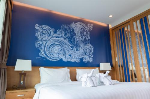 a bedroom with a blue wall with towels on a bed at Aonang Suite Pool Villa in Ao Nang Beach