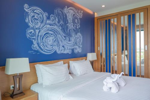 1 dormitorio con 2 camas y pared azul en Aonang Suite Pool Villa, en Ao Nang Beach