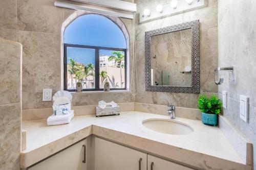 a bathroom with a sink and a mirror at Marina Cabo Plaza Town & Beach Condos in Cabo San Lucas