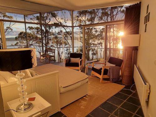 a bedroom with a bed and a view of the ocean at Baragoola Retreat - Luxury Waterfront Property in Sandford