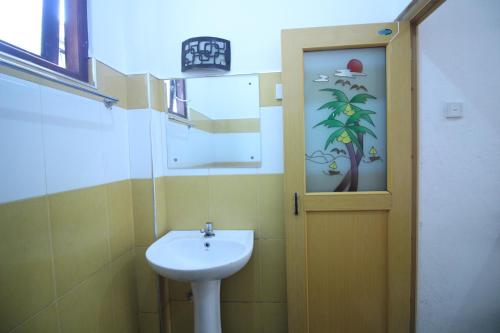 d'une petite salle de bains avec un lavabo et une porte. dans l'établissement White House Holiday Resort, à Matara