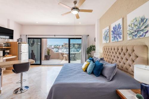 a bedroom with a bed with blue pillows at Marina Cabo Plaza Town & Beach Condos in Cabo San Lucas