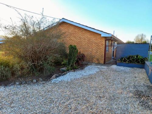 a brick house with a fence and some bushes at 2 Bedroom Self Contained Unit in Gloucester