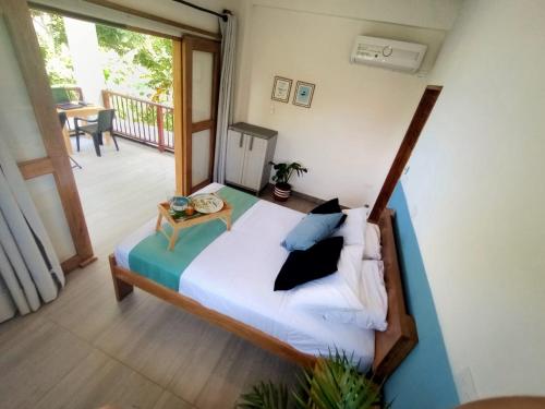 a bedroom with a bed and a balcony with a table at Beach House with AC Surrounded by Nature in Moñitos
