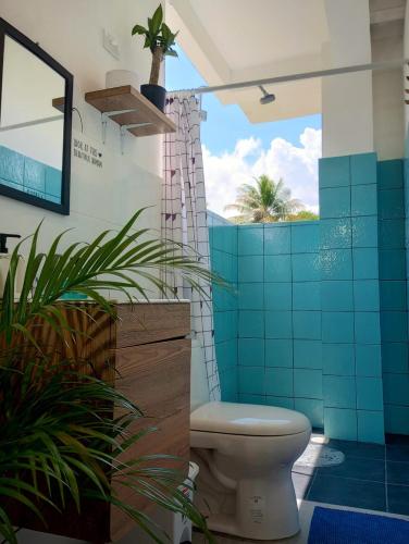 a bathroom with a toilet and blue tiles at Beach House with AC Surrounded by Nature in Moñitos