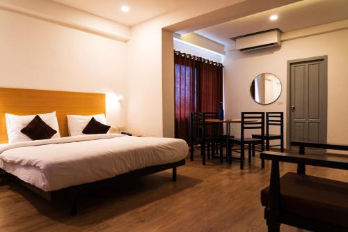 a hotel room with a bed and a table and chairs at Hotel B R REGENCY in Trivandrum