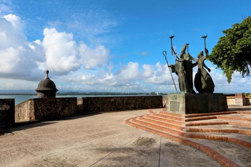 a statue of two women on a staircase near the water at SJ SUITES HOTEL in San Juan