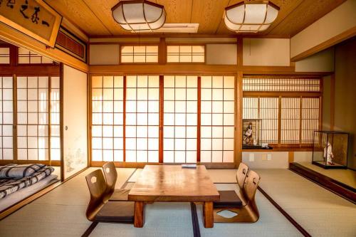 Oimazato大今里民泊 في أوساكا: غرفة مع طاولة وكراسي ونوافذ
