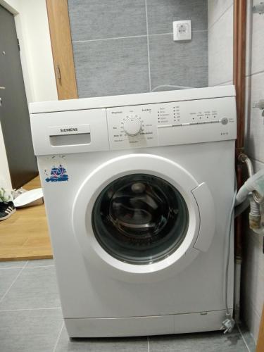 a white washing machine sitting in a kitchen at Sara Lux in Lukavica