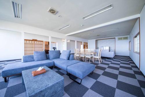 uma sala de estar com um sofá azul e uma mesa em THE VILLA MATSUMAE 
