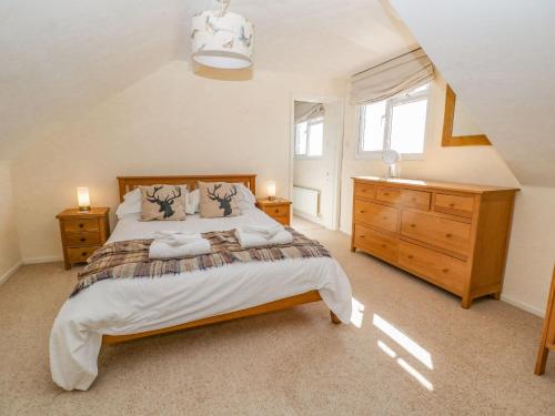 a bedroom with a large bed and a dresser at The Clealings in Witney