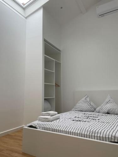 Cette chambre blanche dispose d'un lit et d'un placard. dans l'établissement Appartement atypique et fraîchement rénové, à Saint-Vallier