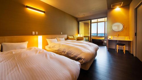 Habitación de hotel con 2 camas y espejo en リゾートホテル美萩, en Hagi