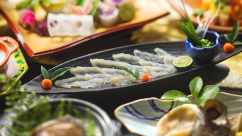 a table with plates of food on a table at リゾートホテル美萩 in Hagi