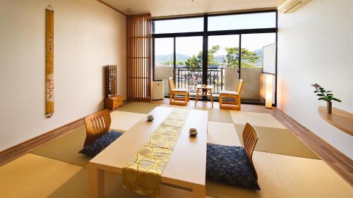a living room with a wooden table and chairs at リゾートホテル美萩 in Hagi
