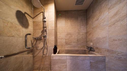 a bathroom with a shower and a sink at リゾートホテル美萩 in Hagi