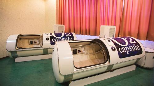 a couple of beds in a room with curtains at リゾートホテル美萩 in Hagi